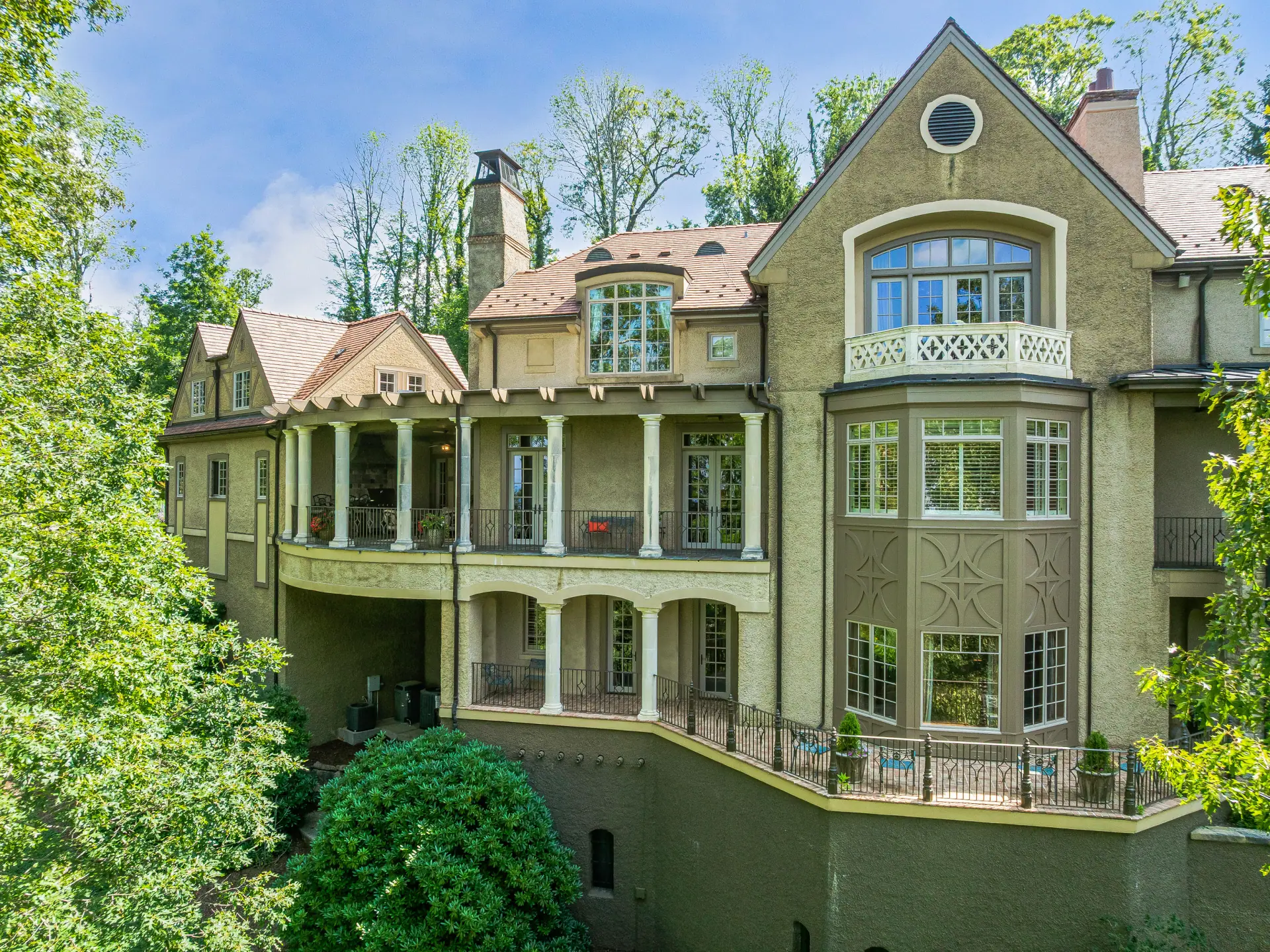 Rear facade with columned terraces and a bay window tower